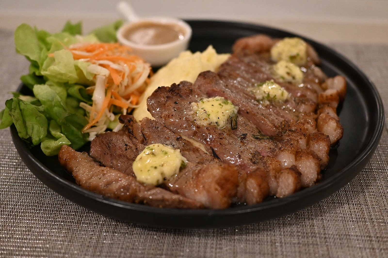 Costilla de res a la brasa, glaseada y jugosa, servida sobre su jugo en el salón de Alma.
